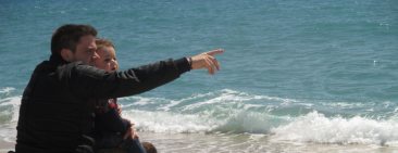 Un pare que va en cadira de rodes a la platja amb el seu fill