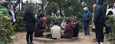 Grup de persones canten reunides al voltant d'una font a l'aire lliure