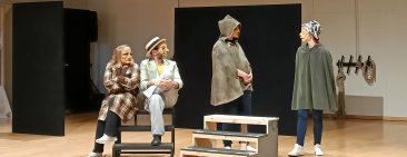 Grup de persones amb màscares de comèdia de l'art representen una escena