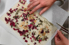 Mans manipulant un biplastic fet amb flors i elements organics