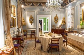 Comedor del Museo del Romanticismo: mesa con vajilla, sillas, aparador con juego de café, en una habitación con ventanas y cortinas