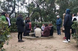 Grup de persones canten reunides al voltant d'una font a l'aire lliure