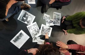 Un grupo de personas está sentado alrededor de unas fotografias antropológicas