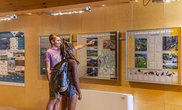 Imatge de un noi i una noia llegint un dels plafons de l'exposició