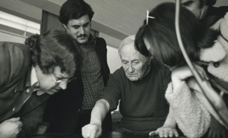 Fotografia on es veu Miró treballant damunt la planxa de gravat de la “Sèrie Mallorca” envoltat de l’equip de la Sala Pelaires.