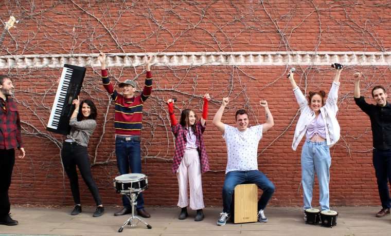 Banda de musica levantan los brazos alegres enseñando sus instrumentos