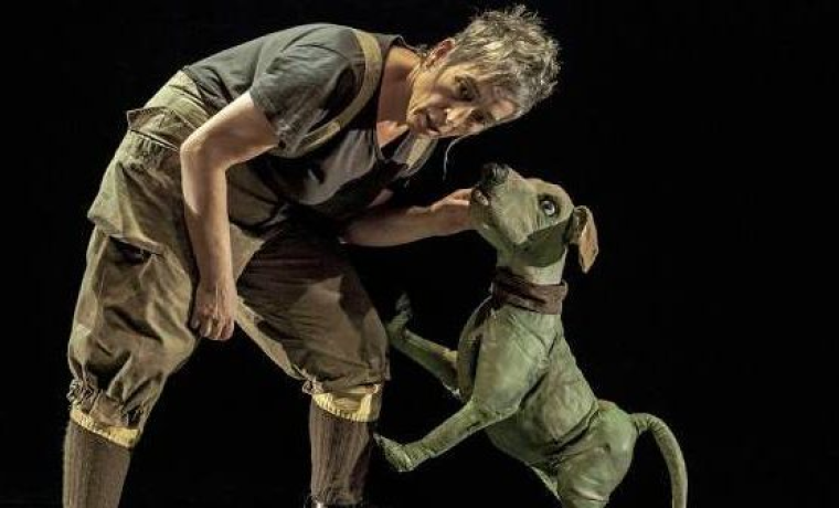 Un actor junto a un títere con forma de perro