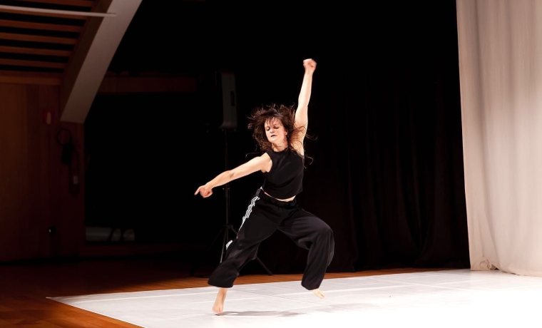 Dona ballant sobre fons negre