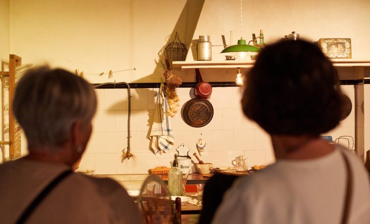 Visitants observant la recreació d'una cuina dels anys 30